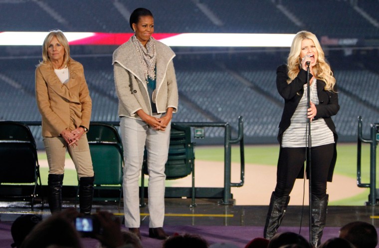 Image: U.S. First Lady Obama and Dr. Jill Biden listen as Simpson sings \"God Bless America\" during an event to support military families, at Coors Field in Denver